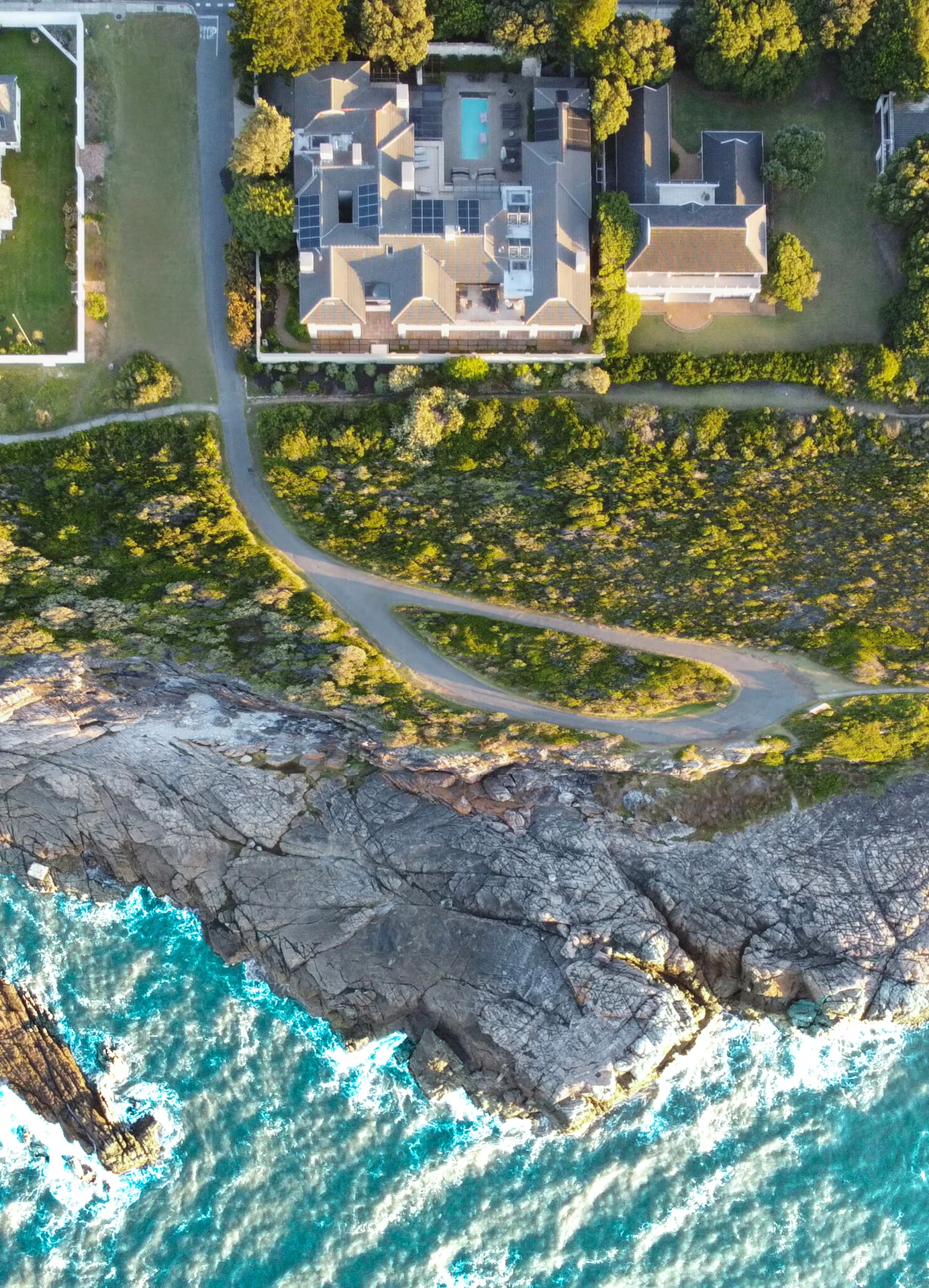 Aerial view of the villa between the coastal road and the ocean