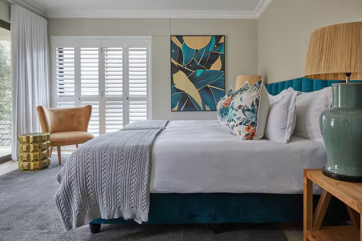 Guest suite with teal headboard and art
